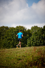 Image showing Sport, man and running in nature for fitness, health and wellness in outdoor for workout or exercise. Male athlete, training and cardio with endurance, muscles and strength for healthy living or jog