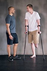 Image showing Physiotherapy, crutches and man with disability in healthcare center for walking, muscle strength and coach for support. Amputee, exercise and physiotherapist for physical therapy with rehabilitation