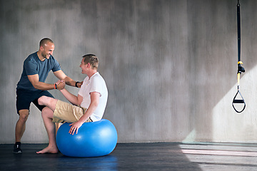 Image showing Amputee, exercise ball and rehabilitation with physiotherapist at gym for training with motivation. Fitness, professional and patient with disability for wellbeing with workout, health and happy