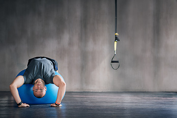 Image showing Man, physio ball and stretch for back strength, health or wellness in fitness studio. Sports trainer, working out and demonstrating exercise for motivation, lumbar mobility and flexibility in gym