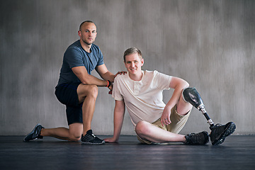 Image showing Trainer, person with a disability and prosthetic leg and posing in physiotherapy, studio and gym ball. Male people, physiotherapist and amputee for wellness, fitness and exercise in sports center