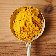 Image showing Top view, spoon and spices with ingredient for food, culinary and flavor with turmeric or curry powder for cooking. Chef tools, ground seasoning for meal and cuisine, catering and natural with aroma