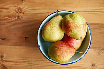 Image showing Home, healthy or bowl of pears in kitchen for healthy, organic or balanced diet for nutrition, meal or snacks. Background, fiber and bunch of natural ingredients with vitamins for fruits or farming