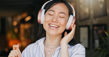 Image showing Happy asian woman, headphones and listening to playlist music in cafe for audio streaming, dancing or singing. Female person or freelancer smile or enjoying podcast, sound or song at coffee shop or r