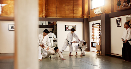 Image showing Aikido dojo, students and fight for martial arts, strike or together for combat at training, gym or class. Japanese people, group and sport for exercise, workout or fitness with zen, conflict or club