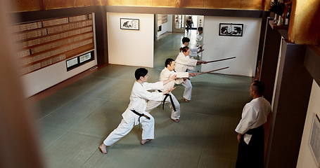 Image showing Aikido students, stick or learning martial arts in dojo for practice, movement or self defense. Combat demonstration, above or Japanese people in training workout for fighting, education or sensei