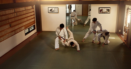 Image showing Japanese men, aikido class or training in fight, modern martial arts or learning self defence. Sensei, black belt students and instruction in dojo place, sport and combat demonstration for discipline