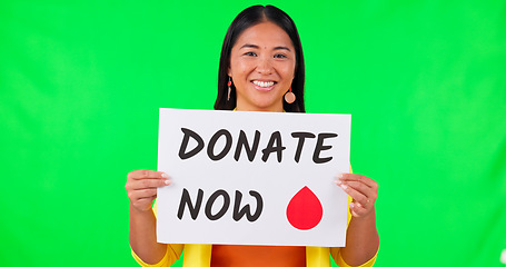 Image showing Asian woman, billboard and blood donation on green screen for advertising against a studio background. Portrait of happy female person with sign or poster in donate, healthcare or volunteer on mockup