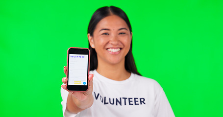 Image showing Phone, green screen and portrait of volunteer woman with charity website fund information mockup. Asian person hand with smartphone and tshirt for nonprofit contact, NGO or donation tracking markers