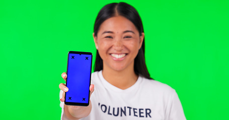 Image showing Phone, green screen and portrait of volunteer woman with charity website fund information mockup. Asian person hand with smartphone and tshirt for nonprofit contact, NGO or donation tracking markers