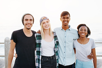 Image showing Friends, group and portrait on beach with hug for travel, bonding and happy outdoor on promenade. Diversity, gen z people and embrace by ocean for holiday, boardwalk and summer adventure in nature