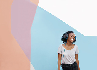 Image showing Music, smile or black woman with headphones in city for sound, track or listening to podcast on wall background. Streaming, mockup or gen z African student outdoor with radio, playlist or audio ebook