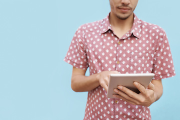 Image showing Tablet, search and hands of man in studio for newsletter, sign up or elearning registration on blue background. Digital, app or gen z student online for ebook streaming, research or upskill education