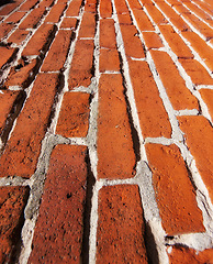 Image showing Building, pattern and closeup of red, brick wall for texture, background and design of exterior structure. Architecture, construction and surface of material, concrete and cement for decoration