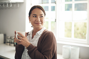 Image showing Woman, relax and thinking with coffee in kitchen for holiday, satisfaction and winter vacation. Asian person, happy and hand with mug for warm beverage, morning routine and weekend enjoyment at home