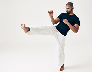 Image showing Man, studio and karate for kick practice, action and martial arts on white background. Black male person, mockup space and training for combat, fight and position of attack in taekwondo for fitness