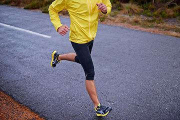 Image showing Cold, legs and man with fitness, running and challenge with endurance and energy with morning cardio. Person, runner or athlete with sneakers, wellness or wet road with hobby, winter or stress relief