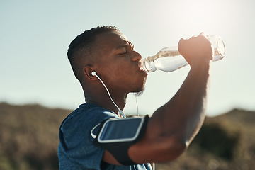 Image showing Black man, drink water and music in outdoors for running, thirst and hydrate on sports break. Person, profile and mineral liquid in bottle for nutrition, athlete and phone app for streaming song