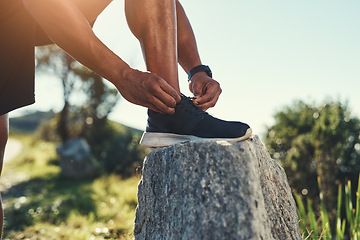 Image showing Runner, legs and tie shoelaces on rock, outdoors and prepare for cardio and marathon training. Man, stone and shoe for exercise or sports in nature, getting ready and foot for workout or athlete