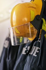 Image showing Uniform, helmet and clothes of firefighter on wall for rescue, emergency service and protection. Fire brigade, safety gear and equipment, outfit and ppe on rack for health department in station