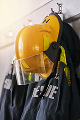 Image showing Uniform, helmet and jacket of firefighter on wall for rescue, emergency service and protection. Fire brigade, safety gear and equipment, outfit and ppe on rack for health department in station