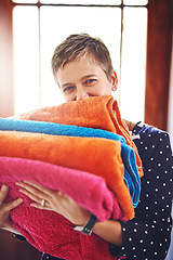 Image showing Laundry, woman and clean towels in portrait after washing, housework and folded material in the morning. Home, housekeeping and cleaner or female person with color fabric or soft cloth as routine