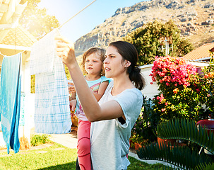 Image showing Backyard, mother and child hanging laundry together with help, teaching and learning chores. Housekeeping, mom and daughter with clean clothes on line outside to sun dry with pegs, care and bonding.