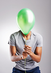 Image showing Man, studio and balloon for fun on background, celebration or surprise or retail promotion with decoration item. Male person, playful and sale on isolated on white backdrop with mockup space