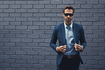 Image showing Confident, man and wall in suit with sunglasses for fashion, style and trendy in outdoor. Male person, pride and project manager for work, corporate and career on grey background in New York City