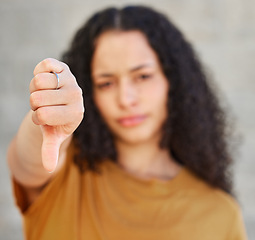 Image showing Hand, rejection and thumbs down with unhappy woman in studio on gray background for denial. Fail, feedback and review with emoji hand gesture of person to express bad, negative or no opinion