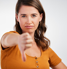 Image showing Woman, portrait and thumbs down rejection in studio for vote, voice or opinion, rating or fail on white background. Face, no or model show emoji feedback, review or warning, gesture or disappointment