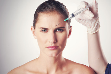 Image showing Woman, portrait and hand with injection in forehead or wrinkles plastic surgery, cosmetics or face lift. Female person, needle and frown lines for anti aging in studio, white background or filler