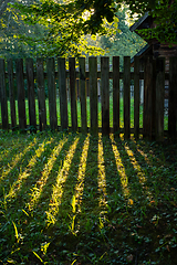 Image showing An old wooden fence in the morning sun