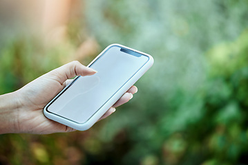 Image showing Mockup, mobile phone and hand of person in park for social media, online communication or browsing internet. Bokeh, scrolling and closeup of woman on smartphone for promotion, copy space or branding