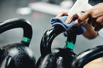 Image showing Gym, cleaning or hand with sanitizer for kettlebell, safety or prevention or germs, virus and bacteria. Weights, spray or sports club janitor with dust cloth, liquid or hygiene of workout equipment