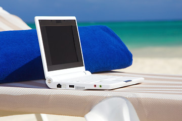 Image showing laptop and towel on the beach chaise longue
