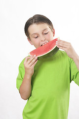 Image showing Boy eating a piece of watermelon