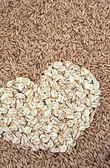 Image showing Oats seeds and oat-flakes heart - background