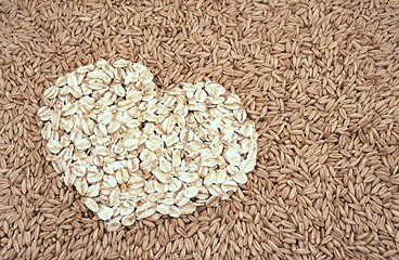 Image showing Oats seeds and oat-flakes heart - background