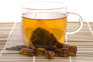 Image showing white tea, nylon tea-bag and golden sugar