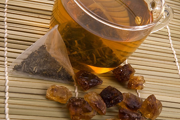 Image showing white tea, nylon tea-bag and golden sugar