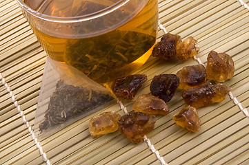 Image showing white tea, nylon tea-bag and golden sugar