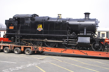 Image showing black steam locomotive on  a transporter