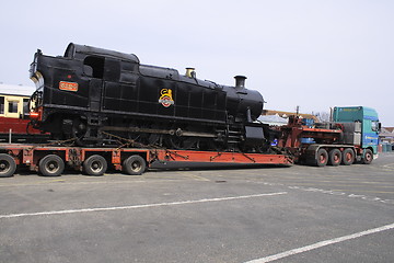 Image showing black steam locomotive on  a transporter