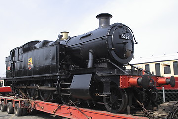 Image showing black steam locomotive on  a transporter