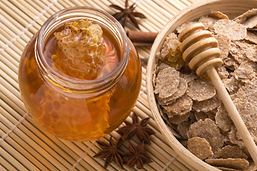 Image showing fresh honey with honeycomb, spices and breakfast flakes