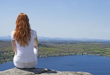 Image showing Young woman on top of a mountain