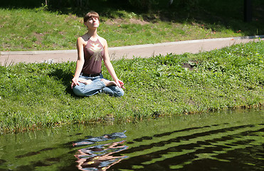 Image showing girl meditating near by water