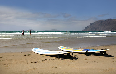Image showing Two surfboards on sandy beach with ocean in background