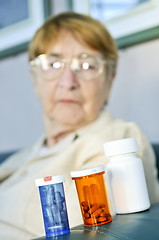Image showing Elderly woman with pill bottles